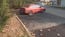 Město chtělo opravit parkoviště, část je bez asfaltu kvůli opuštěnému vraku