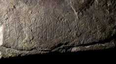 Archeology nadchl prastarý runový kámen. Nad nápisem si lámou hlavu