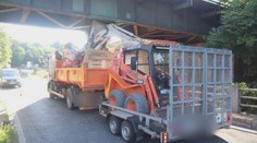 Kuriózní nehoda v Semilech. Nákladní auto s bagrem na korbě se zaseklo o most