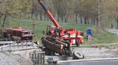 Traktor skončil v rybníku. Nad vodou ho držel valník se dřevem
