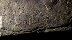 Archeology nadchl prastarý runový kámen. Nad nápisem si lámou hlavu