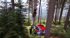 Poryv větru odhodil paraglidistu mezi stromy, zůstal viset vysoko v korunách!