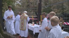 U shořelého kostela zůstal dřevěný kříž, věřící se u něj sešli