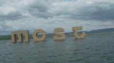 Nápis na jezeře v Mostu se stal atrakcí. Lidé na něm přes zákaz i posedávají