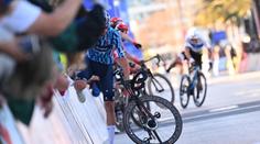 Chaos na trati. Cyklisté špatně odbočili, pak museli lézt přes plot