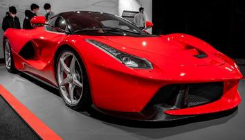 Aktivisté se na výstavě aut přilepili ke sporťákům Ferrari a polili je barvou