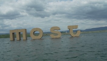 Nápis na jezeře v Mostu se stal atrakcí. Lidé na něm přes zákaz i posedávají