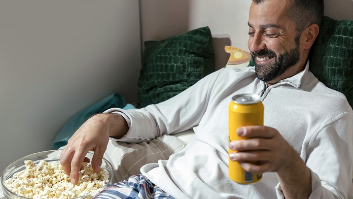 Muž s plechovkou a popcornem