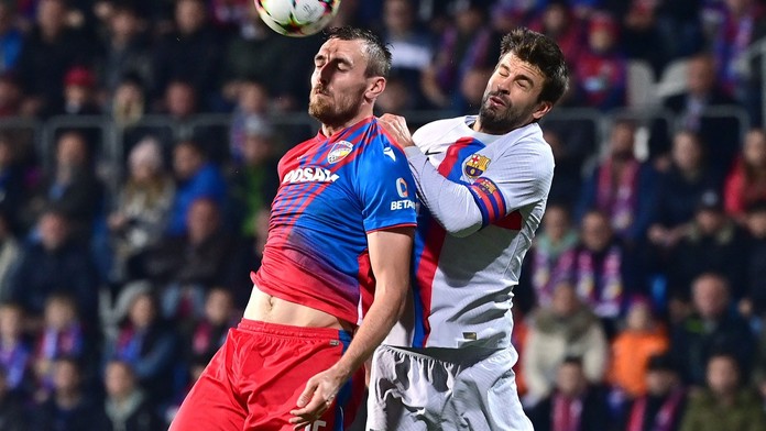 Tomáš Chorý ve vzdušném souboji s Gerardem Piquém z Barcelony
