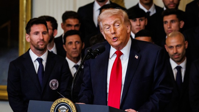 Donald Trump při svém proslovu a Lionel Messi v pozadí