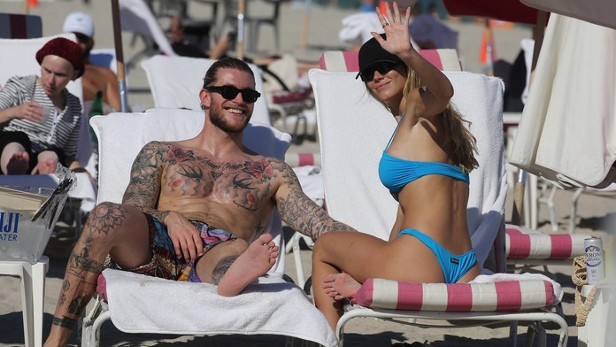 A je to venku. Brankář Karius a krásná reportérka čekají miminko