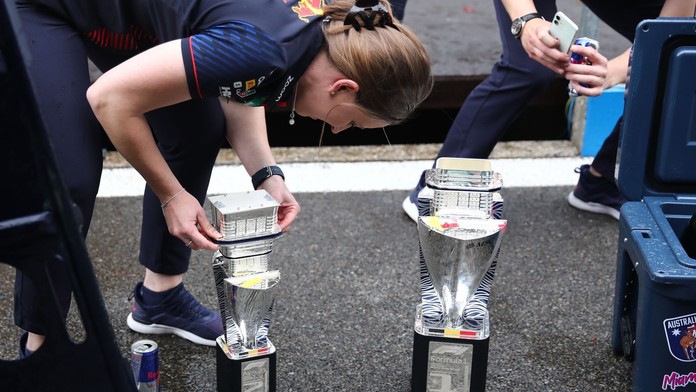 Členka týmu Red Bull se snaží opravit rozbitý pohár
