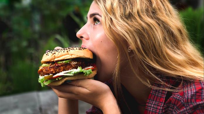 Žena si pochutnává na hamburgru