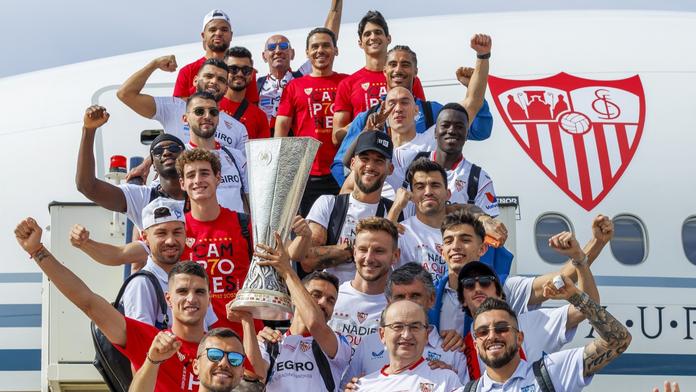 Fotbalisté Sevilly vystupují z letadla s trofejí pro vítěze Evropské ligy