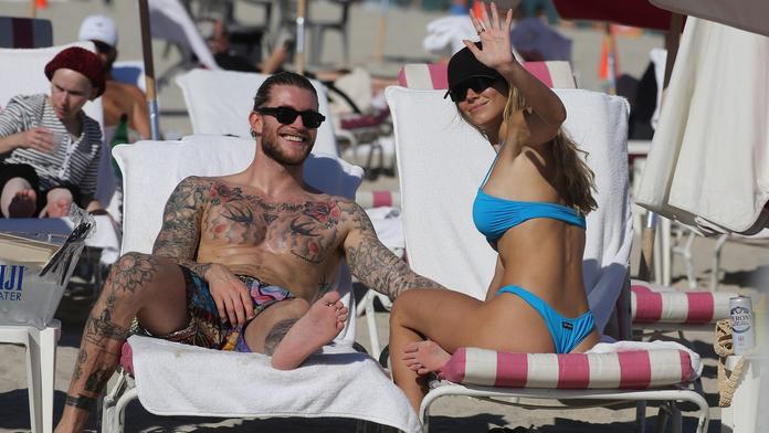 A je to venku. Brankář Karius a krásná reportérka čekají miminko
