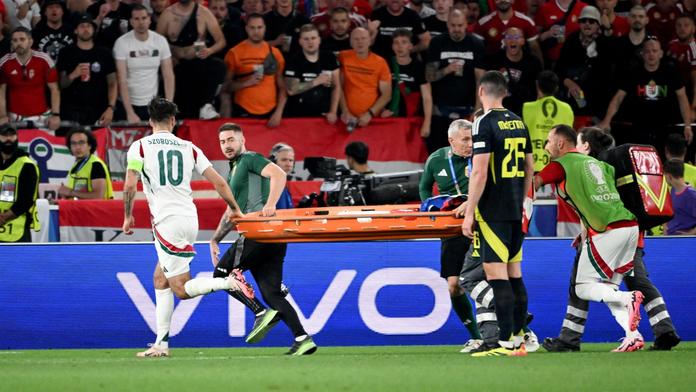 Dominik Szoboszlai pomáhá medikům přinést nosítka pro zraněného Vargu