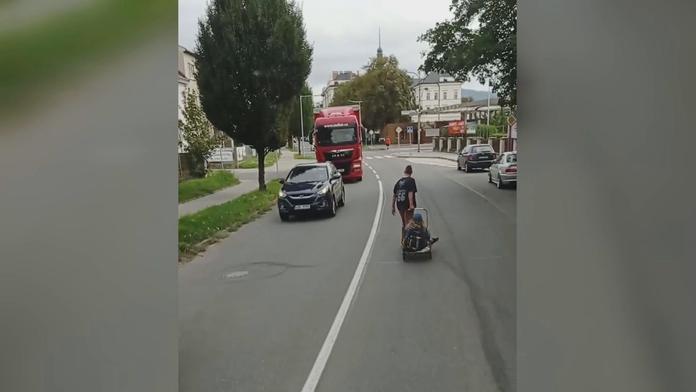 Muž táhne ženu na kárce