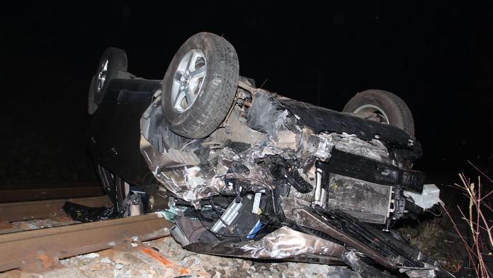 Řidič vylétl ze silnice na koleje, auto převrátil. Zranil se on i pes