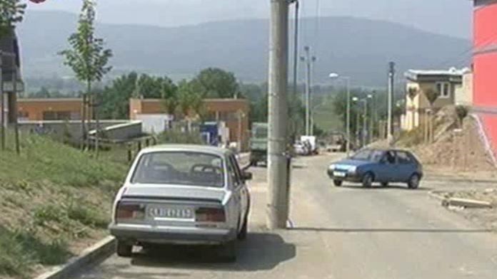 Uprostřed silnice stojí elektrické sloupy