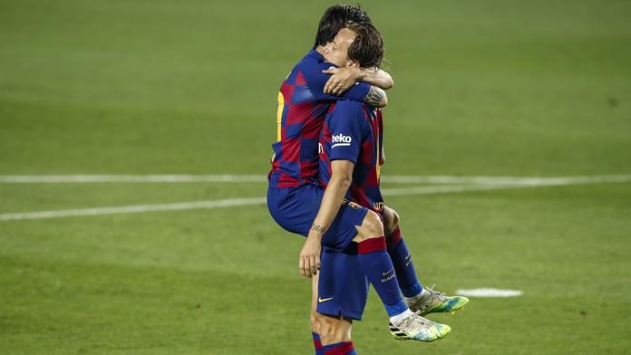Lionel Messi objímá svého spoluhráče z Barcelony Ivana Rakitiče