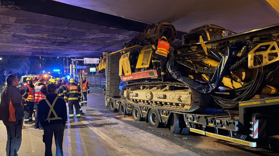 Kamion s bagrem uvízl pod mostem v Praze. Hasiči povolali statika