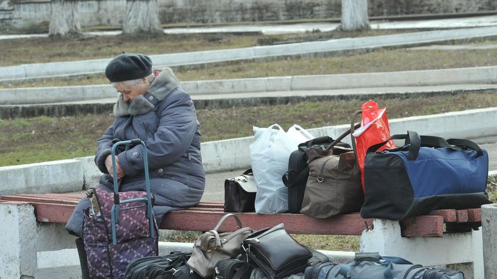 Starší žena čeká na evakuaci osobního vlaku z Lysyčanska