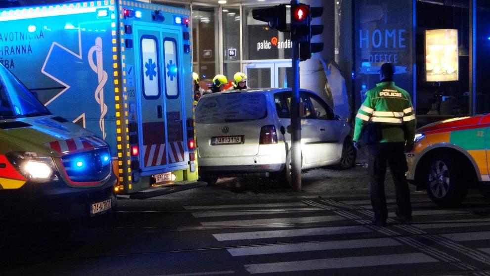 Auto prolétlo křižovatkou a zastavilo se o roh paláce.