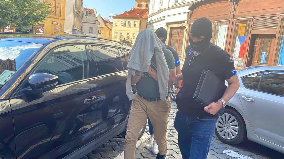 Kriminalisté přivádí zadrženého