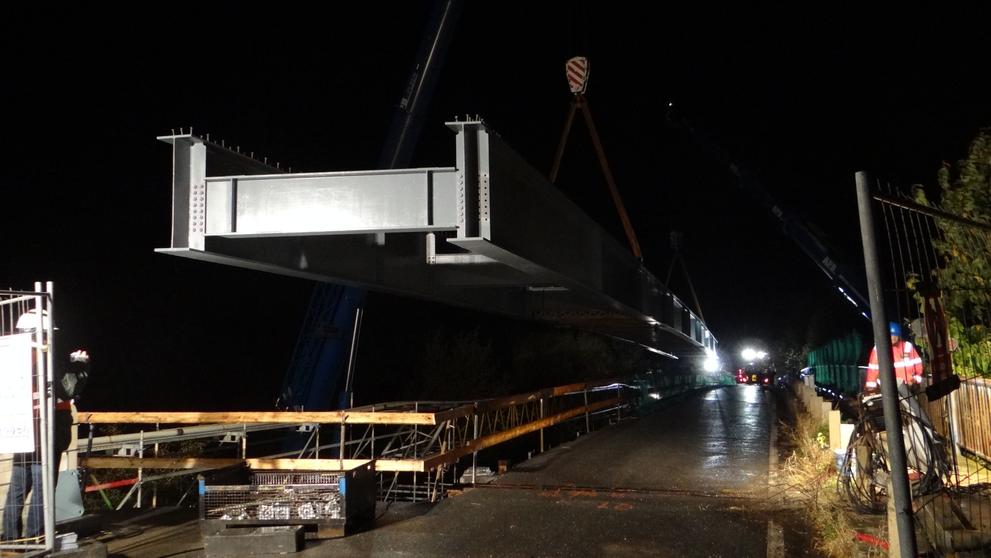Mohutný nosník osazovali dělníci pomocí dvou jeřábů