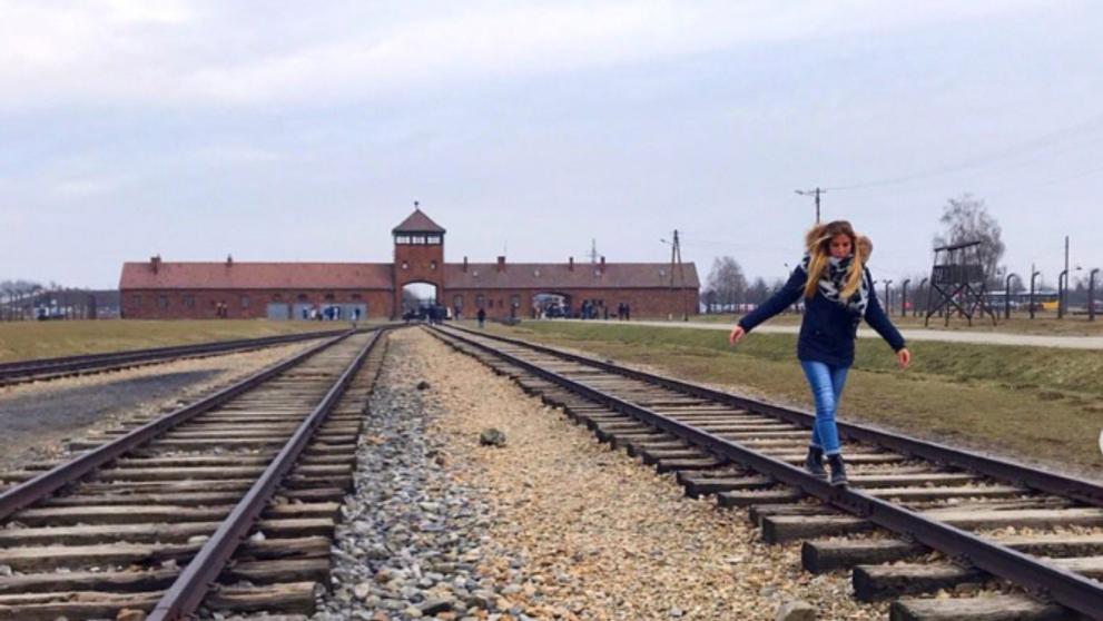 Návštěvníci Osvětimi pózují na kolejích smrti - 3