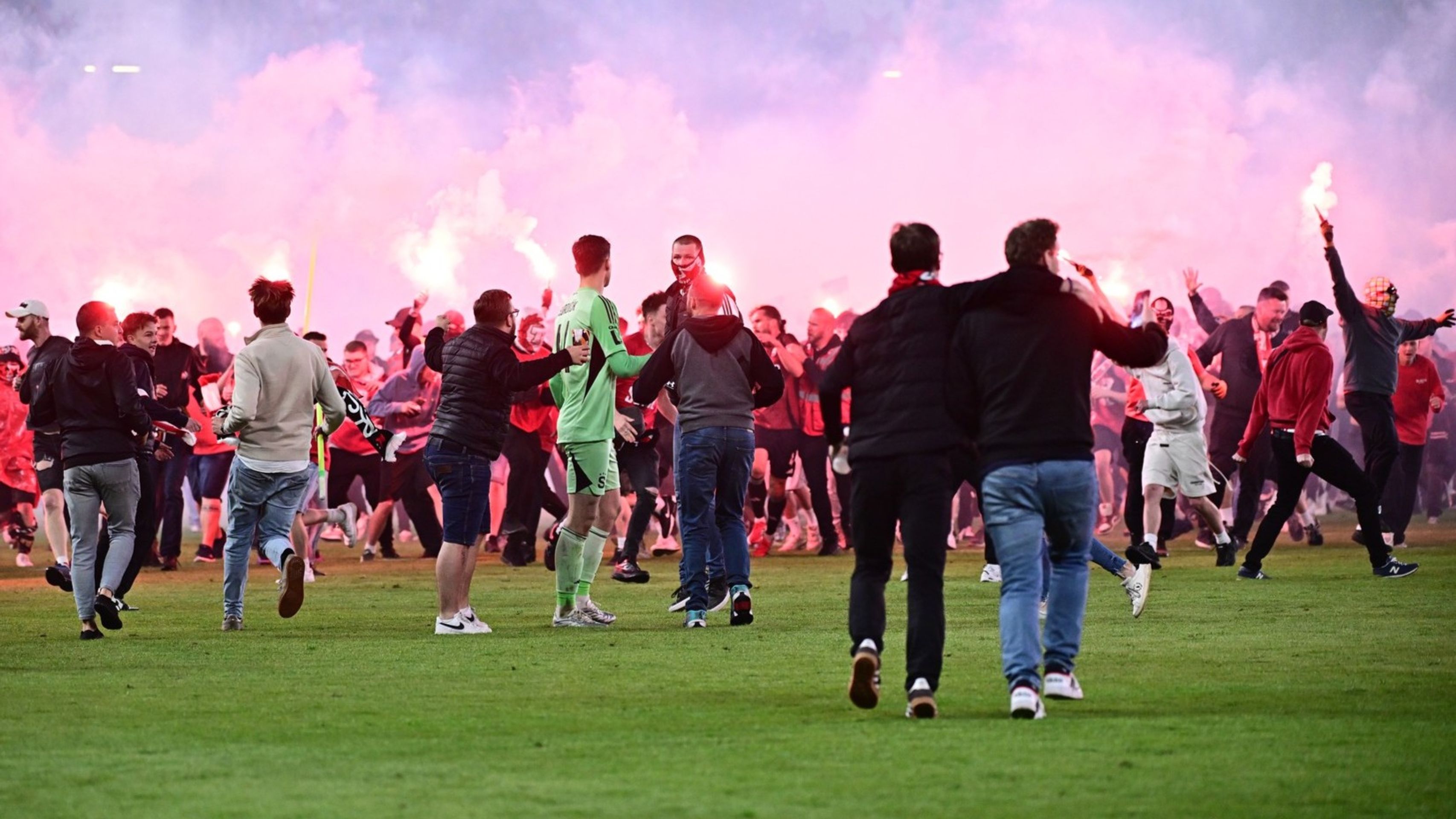 Brankář Sparty Jakub Surovčík (uprostřed) během řádění fanoušků Slavie - Fanoušci Slavie běsnili na hřišti při derby (4/9)