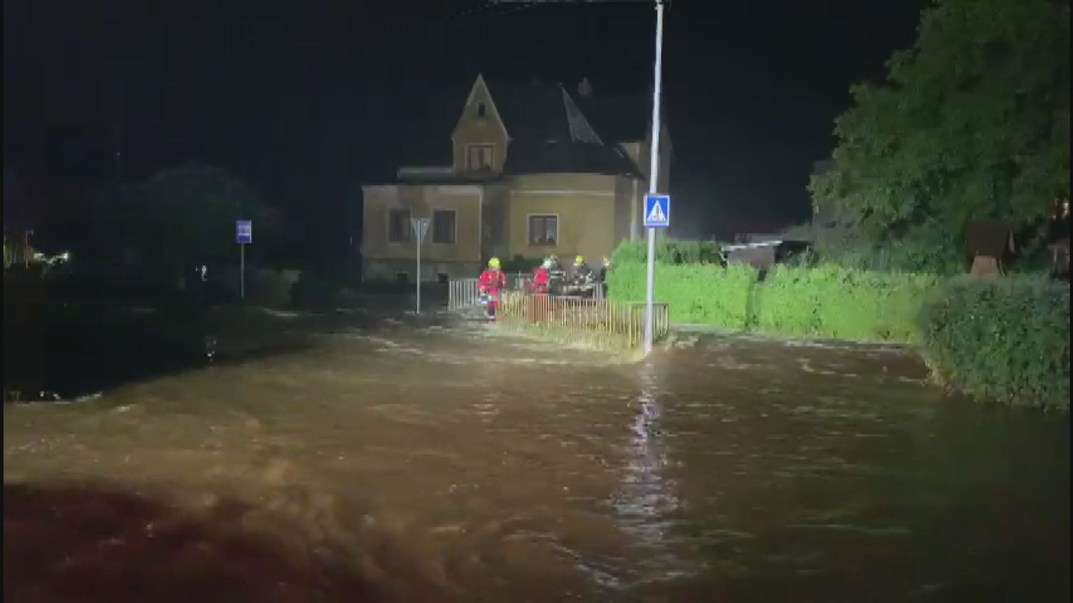 Hasiči stříhají zábradlí přes potok v Horní Poustevně, aby uvolnili průtok vody - GALERIE: Bouřky a povodně v Česku (9/9)