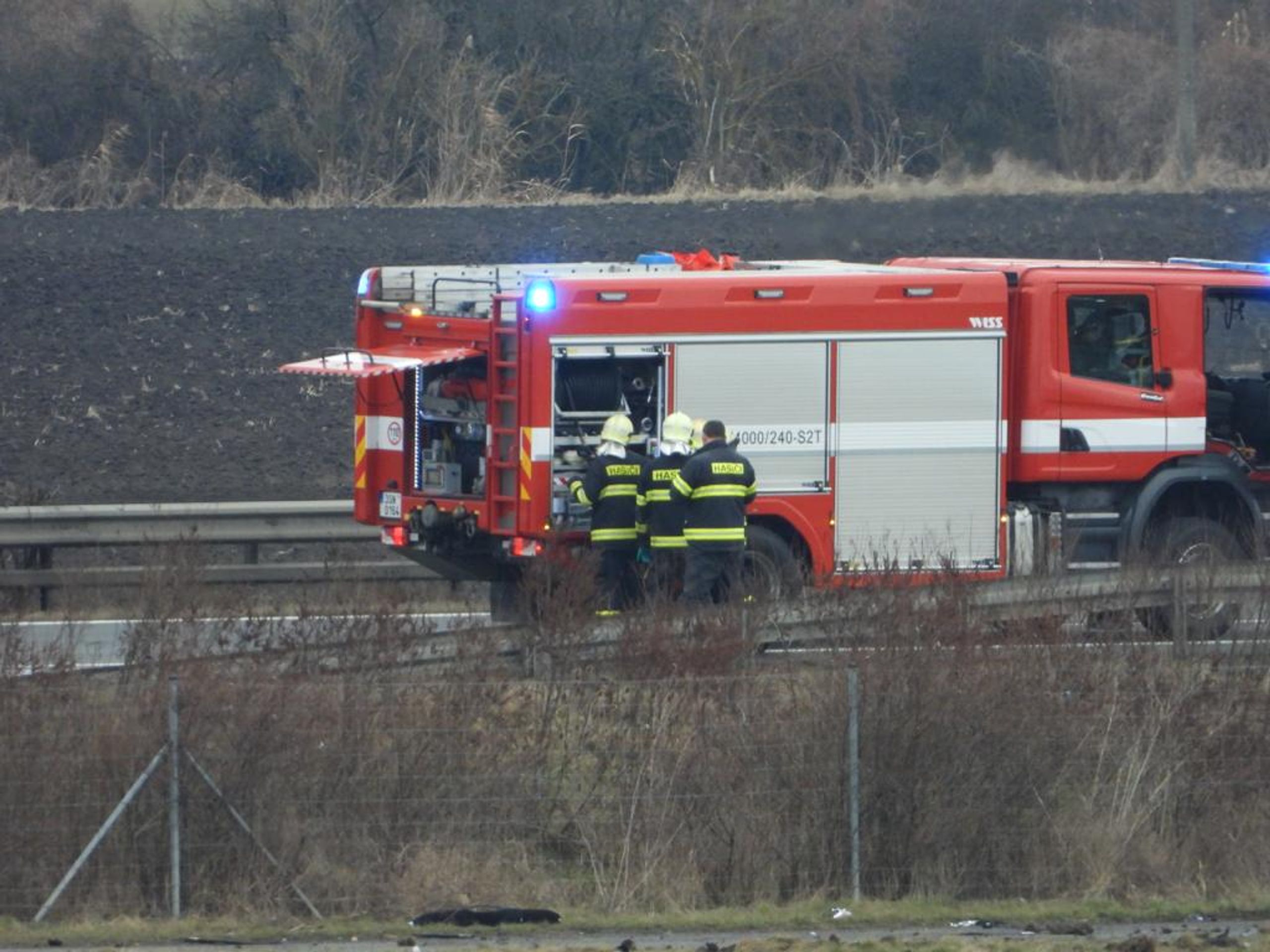 Ohořelé auto u D11 - Požár auta u dálnice D11 (1/2)