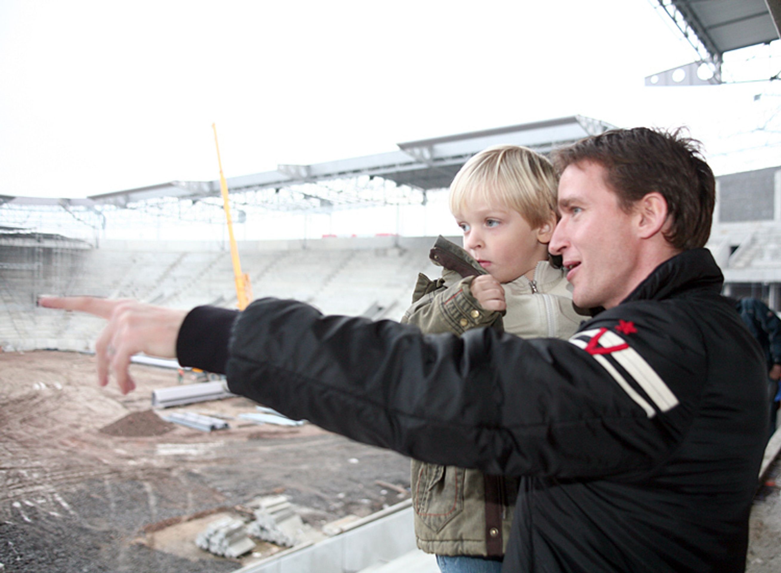 Fotbalista Vladimír Šmicer ukazuje na novém stadionu Slavie synovi, kam bude dávat góly. - Slavia v novém Edenu přivítala Mikuláše (2/4)