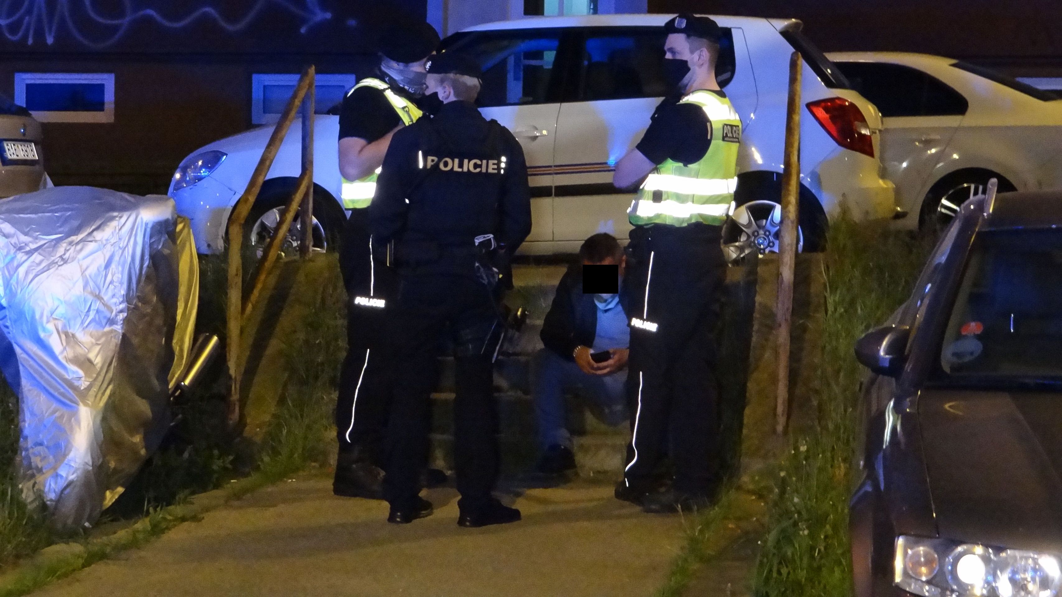 Řidič pod dohledem policistů odevzdaně seděl na schodech a čekal na odvoz k odběru krve - GALERIE: Opilý taxikář naboural v Praze sedm aut (5/5)
