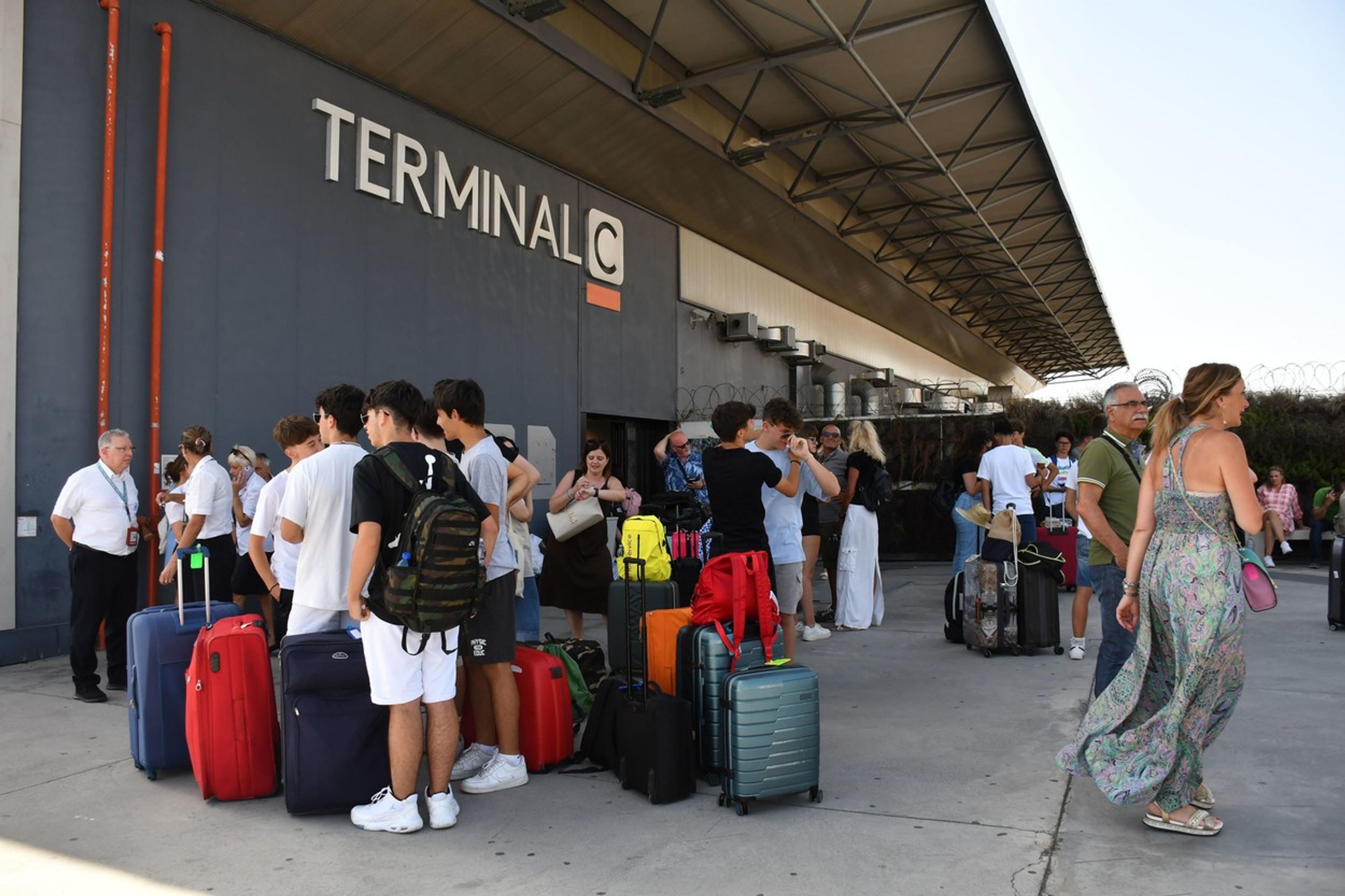 Lidé čekající před terminálem kvůli požáru na letišti - Požár letiště v Itálie (3/3)