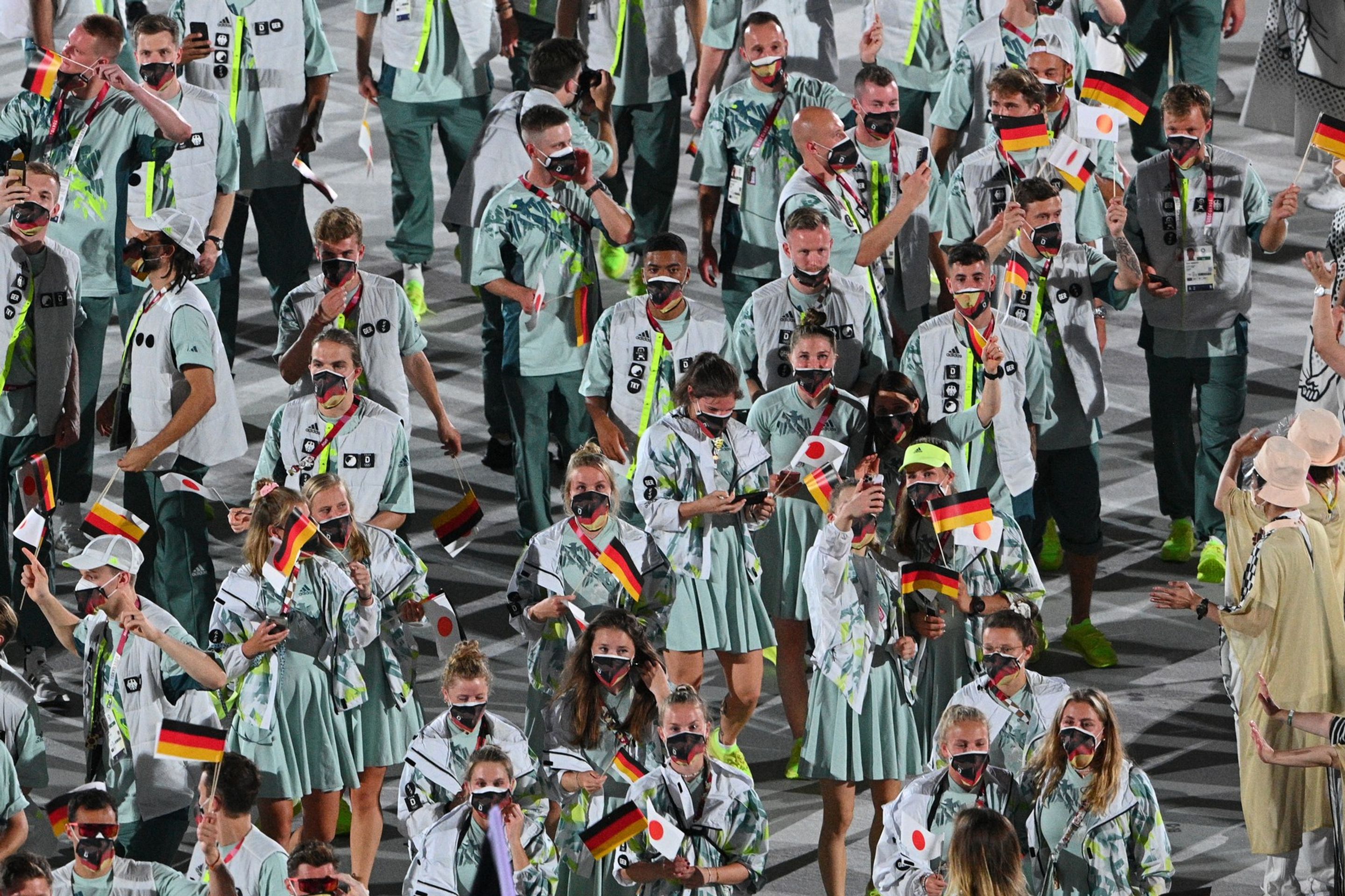 Němci nastoupili ve velmi netradiční barvě a nesli i japonské vlaječky - Galerie: Originální outfity při zahajovacím olympijském ceremoniálu (4/17)