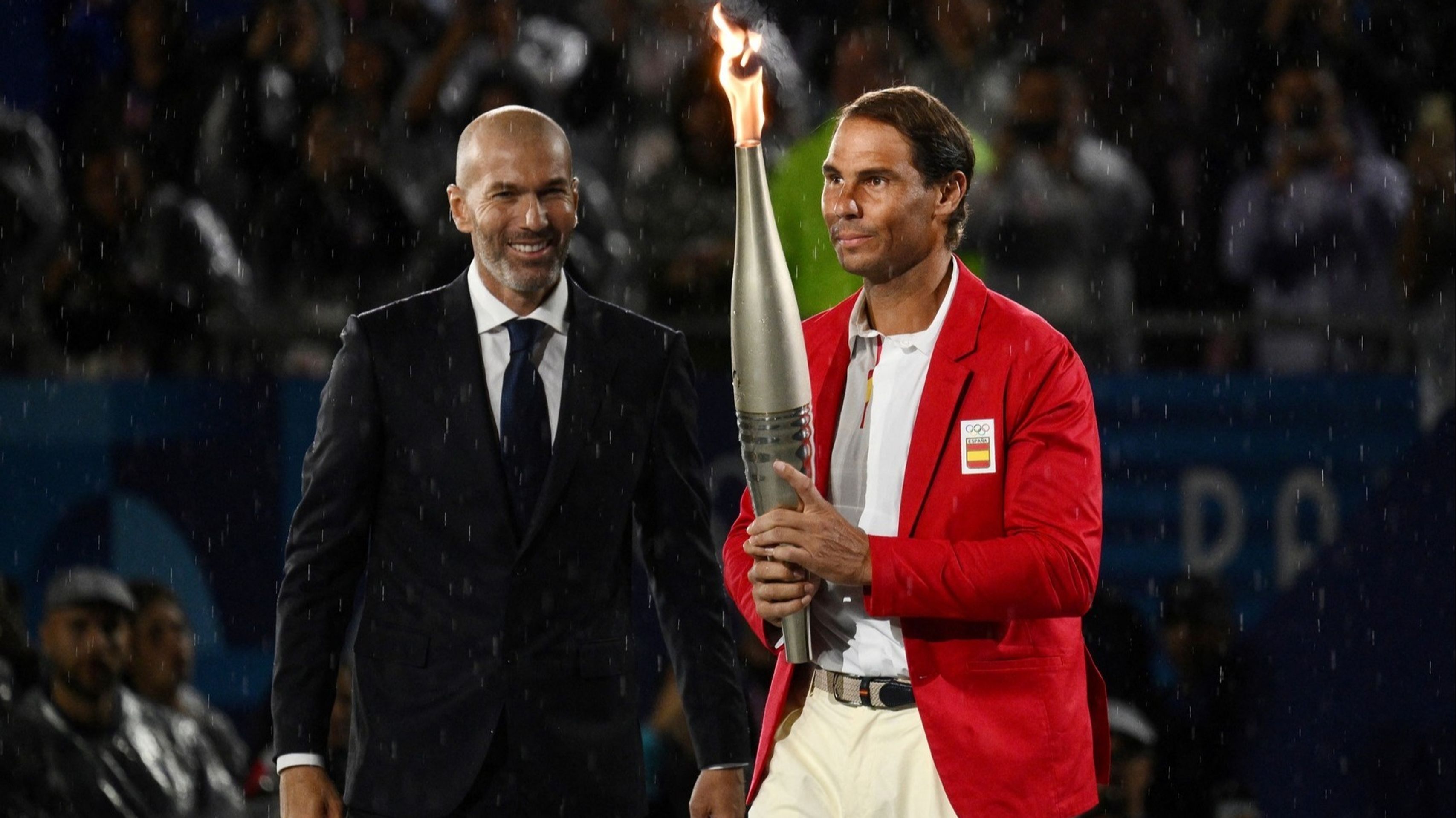 Fotbalista Zinedine Zidane předává olympijský oheň Rafaelu Nadalovi (cropped) - Zahajovací ceremoniál olympijských her v Paříži (6/10)
