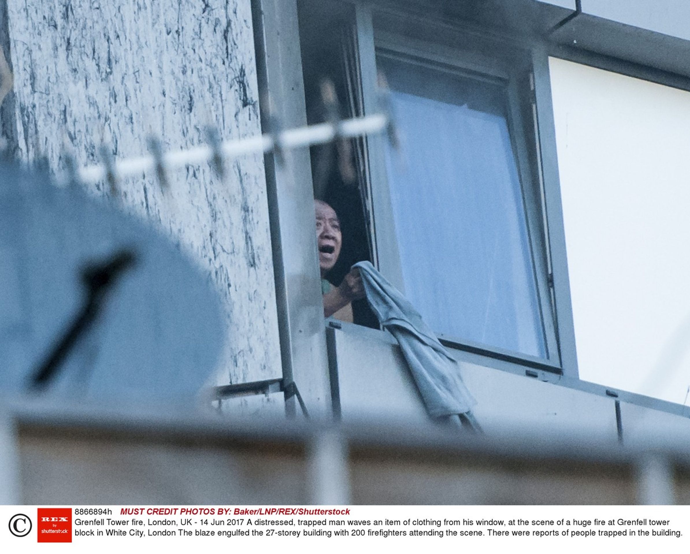 Muž v okně hořící budovy v Londýně - GALERIE: Obrovský požár věžáku v Londýně (1/14)