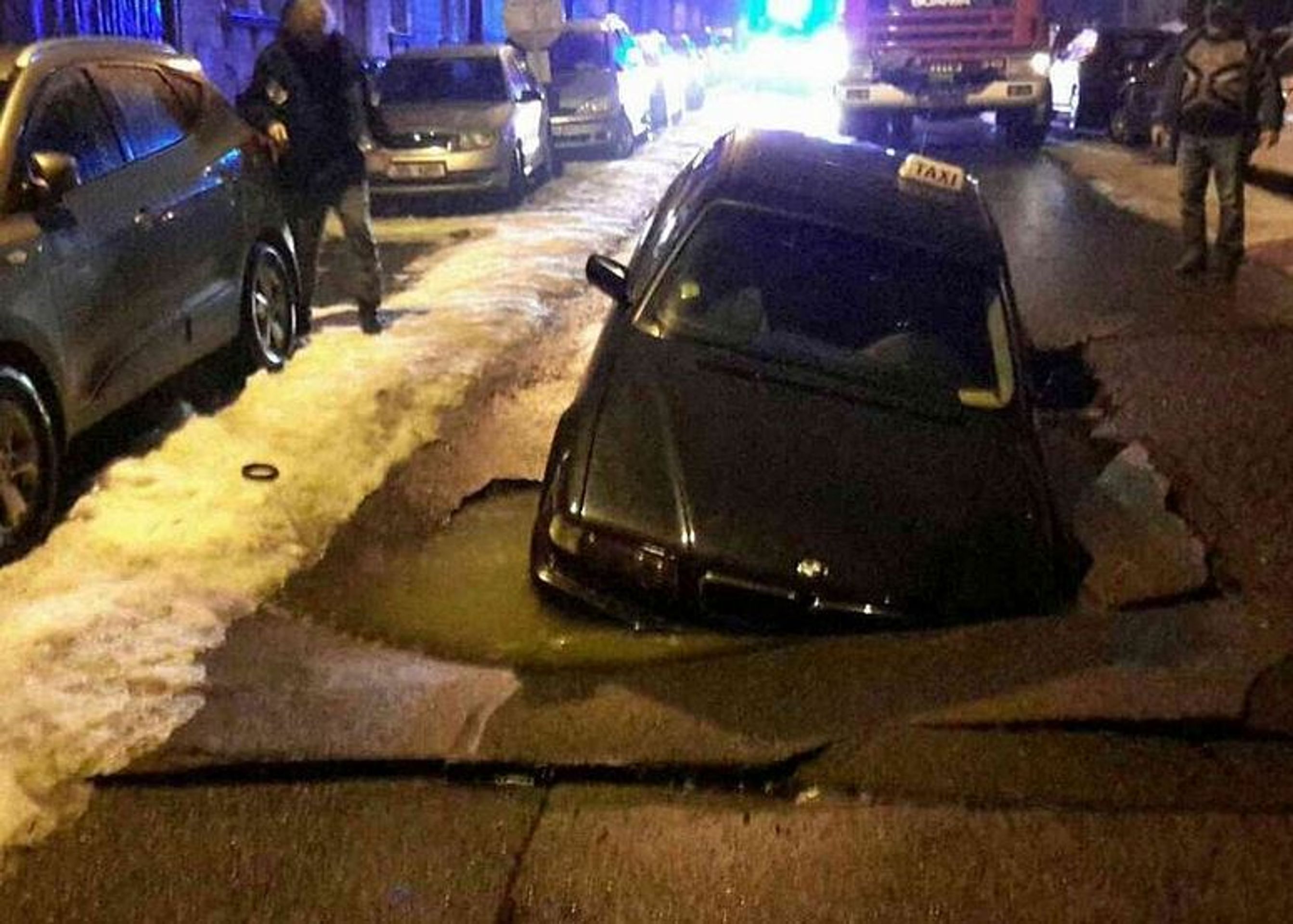 Auto taxi pohltila díra v silnici - 1 - GALERIE: Auto v Chebu pohltila díra v zemi (6/6)