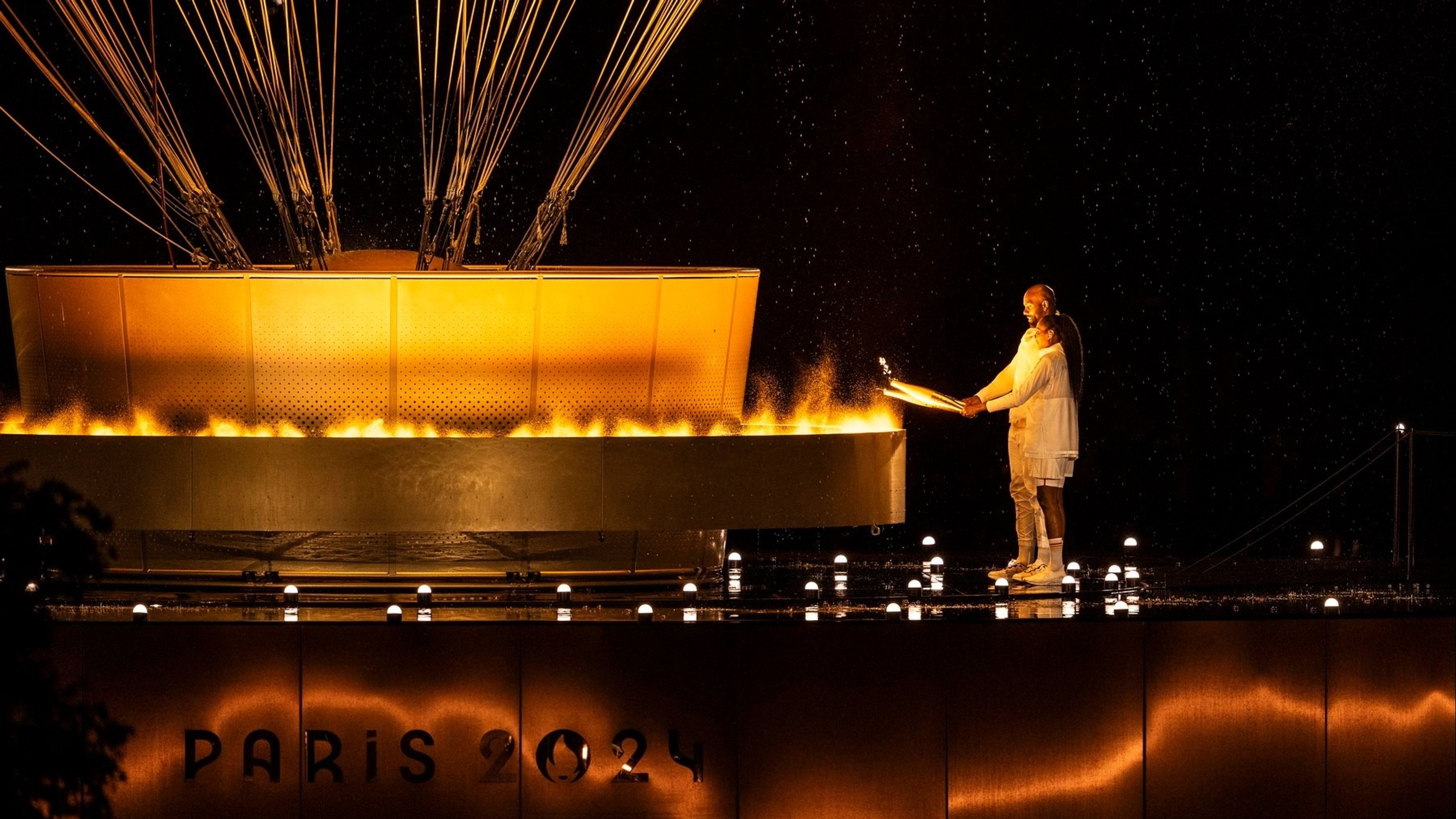 Judista Teddy Riner a bývalá atletka Marie-José Pérecová zapalují olympijský oheň (cropped) - Zahajovací ceremoniál olympijských her v Paříži (9/10)